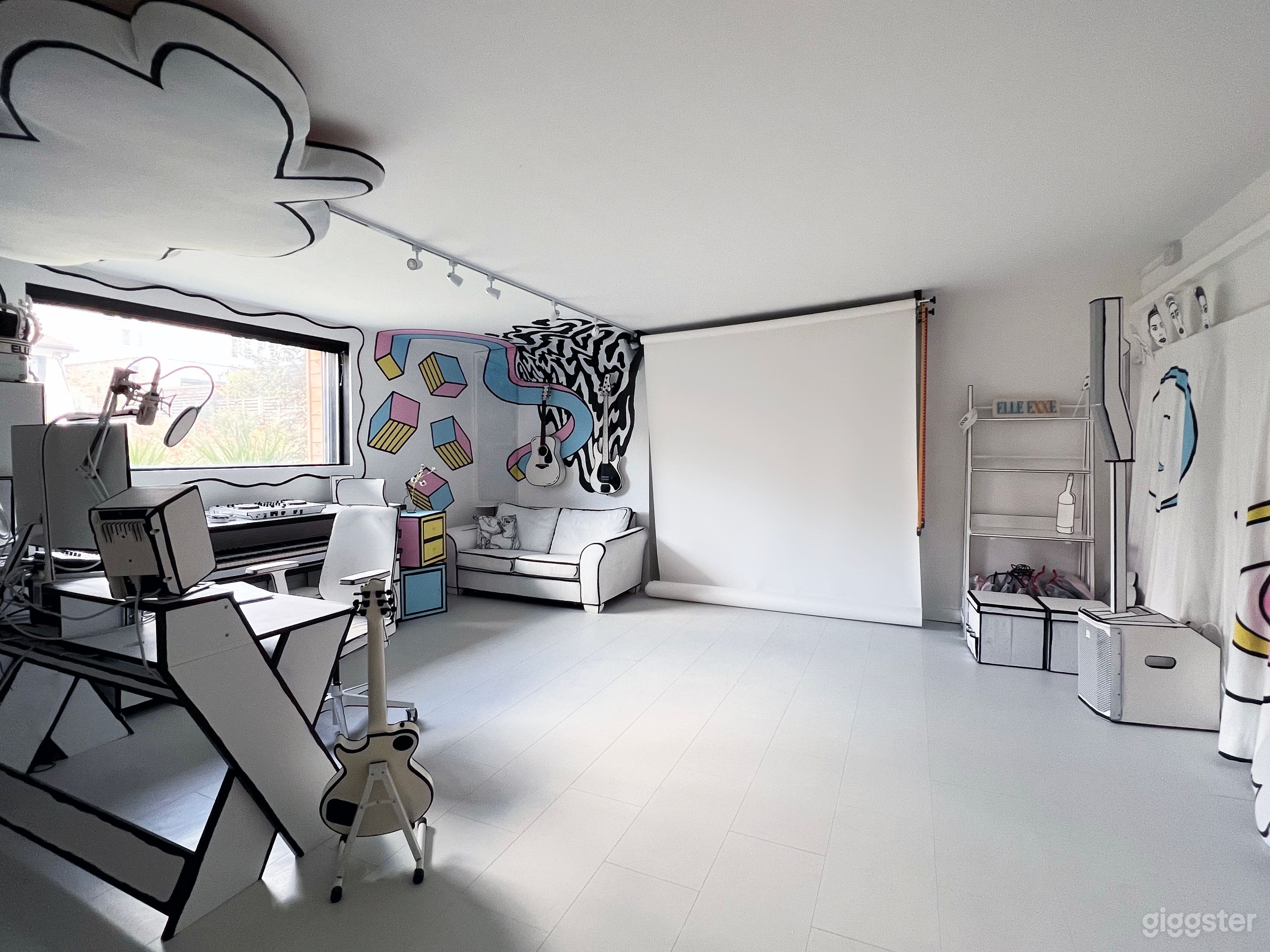 The main space. On the left is the music production area. In the centre is a white photography backdrop on a roller. On the right, curtains cover the mirrored dancing space. 