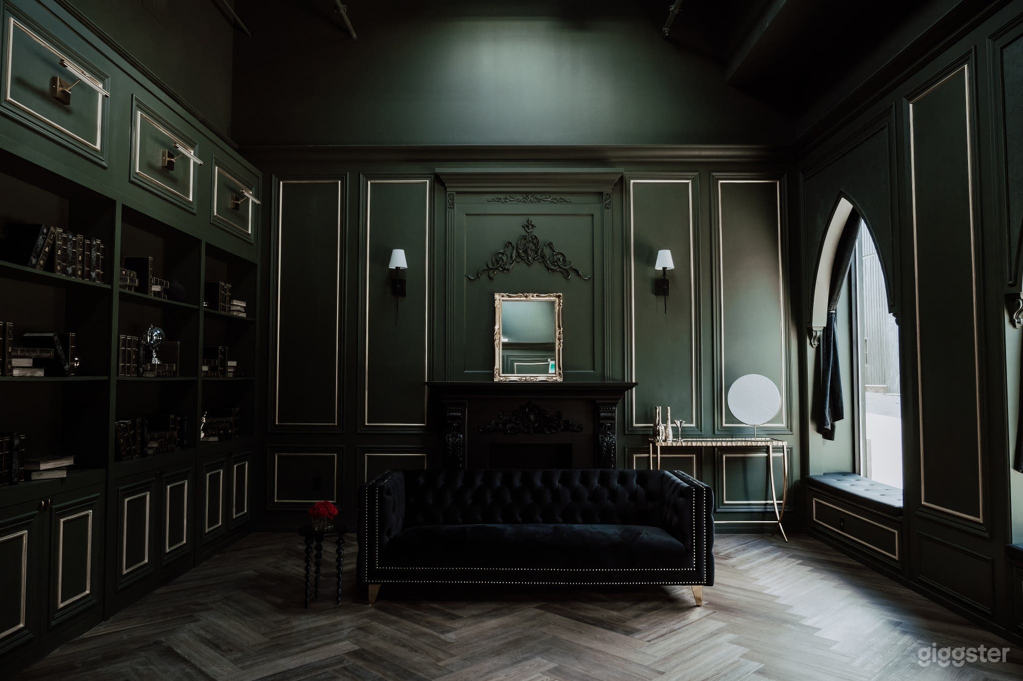 Rich and luxurious dark green room with black and gold accents and dark-themed furniture, evoking opulence and sophistication in our elegant studio space.