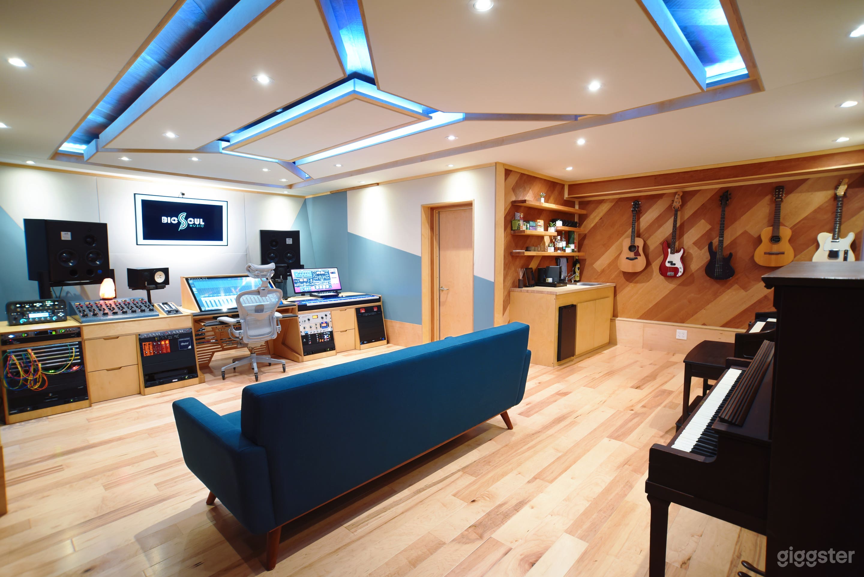 Control room view from studio entrance. Kitchenette on the right by the basses and guitars. Out of view on the left is the isolation booth. The door straight ahead leads to the studio bathroom.