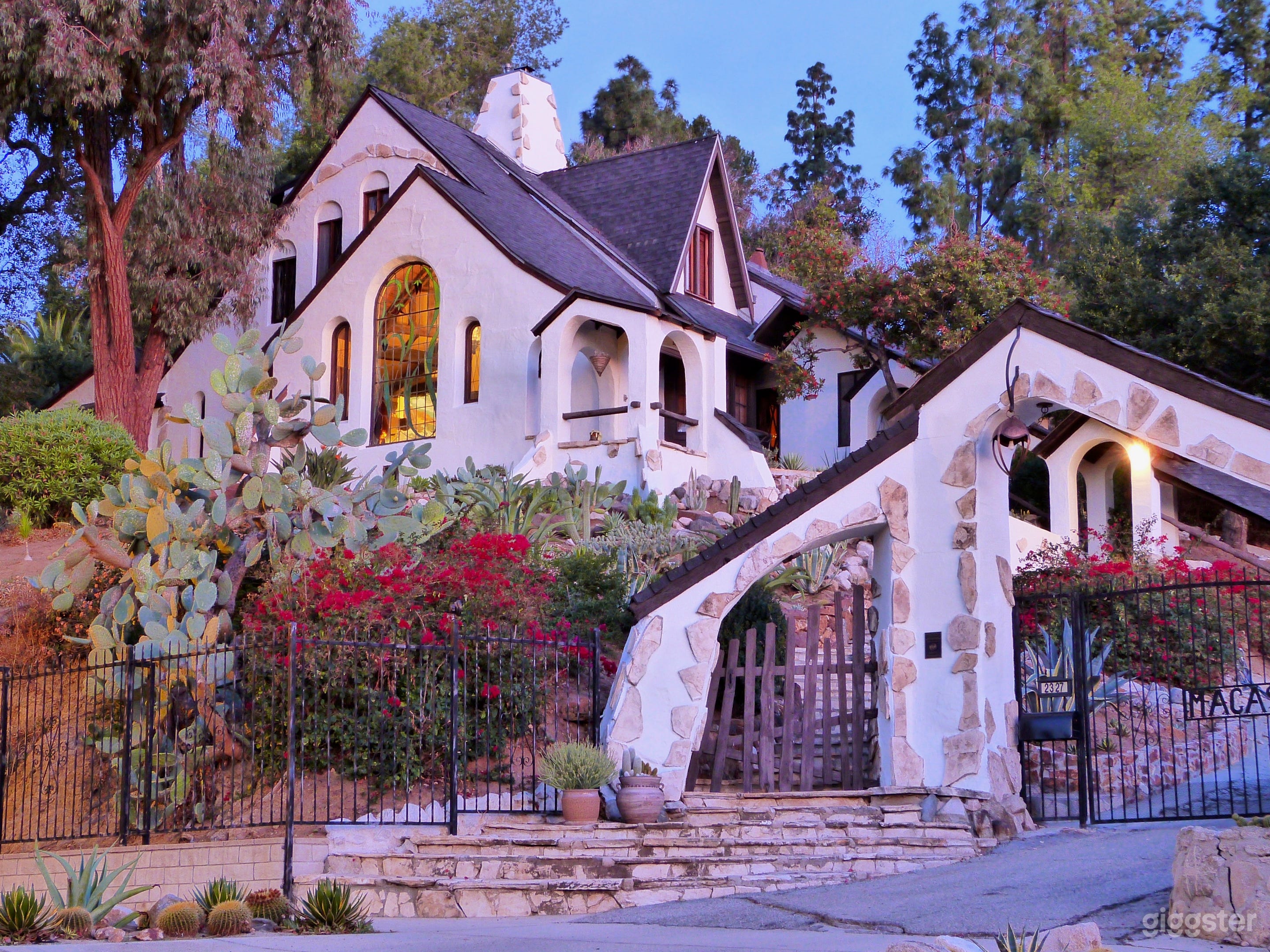 Front of house at dawn from across the street. The massive double arches over the driveway greet you. 
