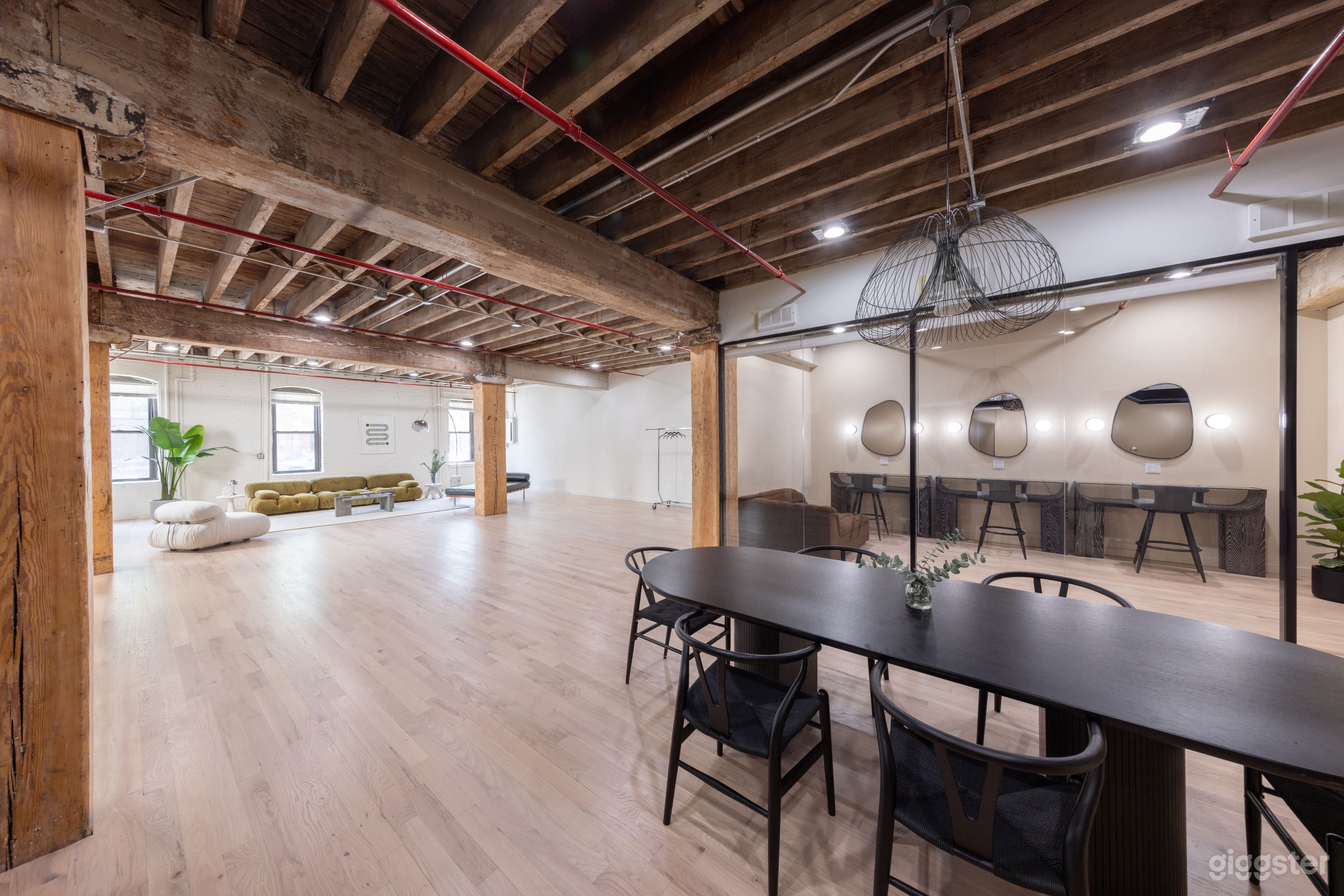 Wide view of the studio space showcasing ample shoot space, dedicated hair and makeup salon, and dining to flex workspace.