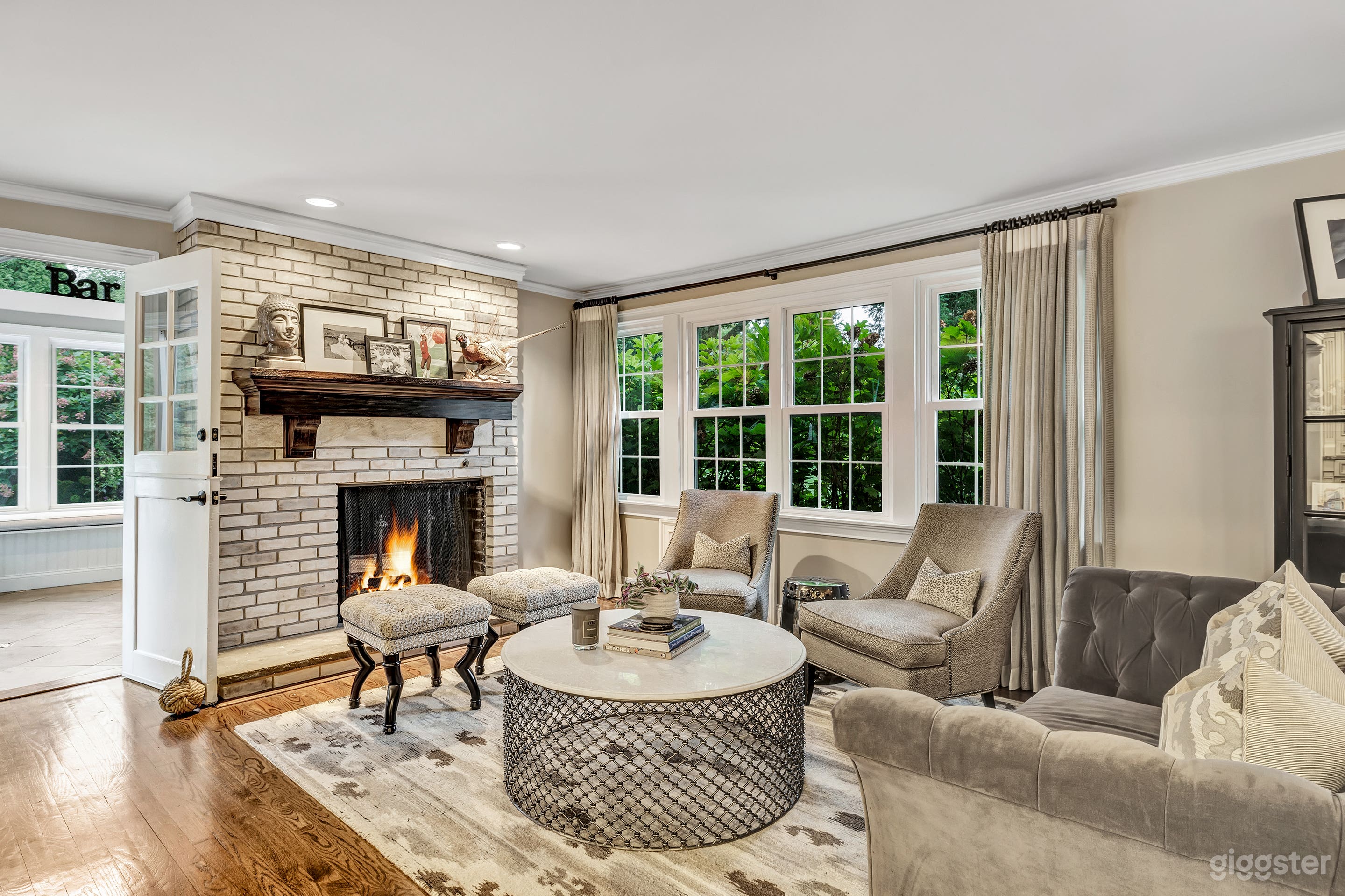 Formal seating area facing pool/bar area and featuring wood burning fireplace and large picture window overlooking front yard.