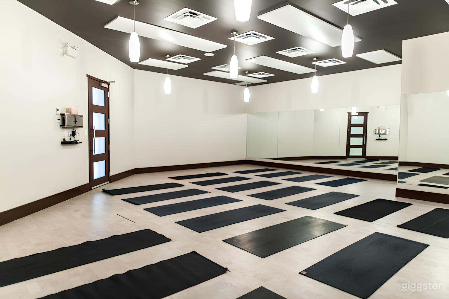 Bright and Spacious Studio: An expansive yoga space with polished wooden floors and clean lines, perfect for filming or hosting intimate workshops.