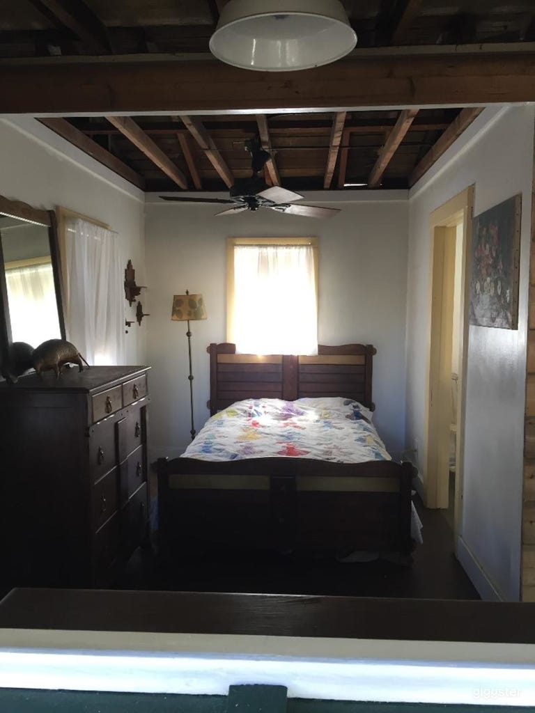  4 piece matching 1930 Ranchero hand painted bedroom set with floor lamp and mirror. Open ceiling has 1930 fan. Wood floor. 