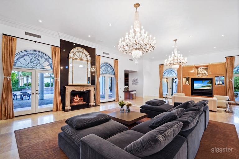  marble floored living room with fireplace and sunken bar. leads out to the pool area 