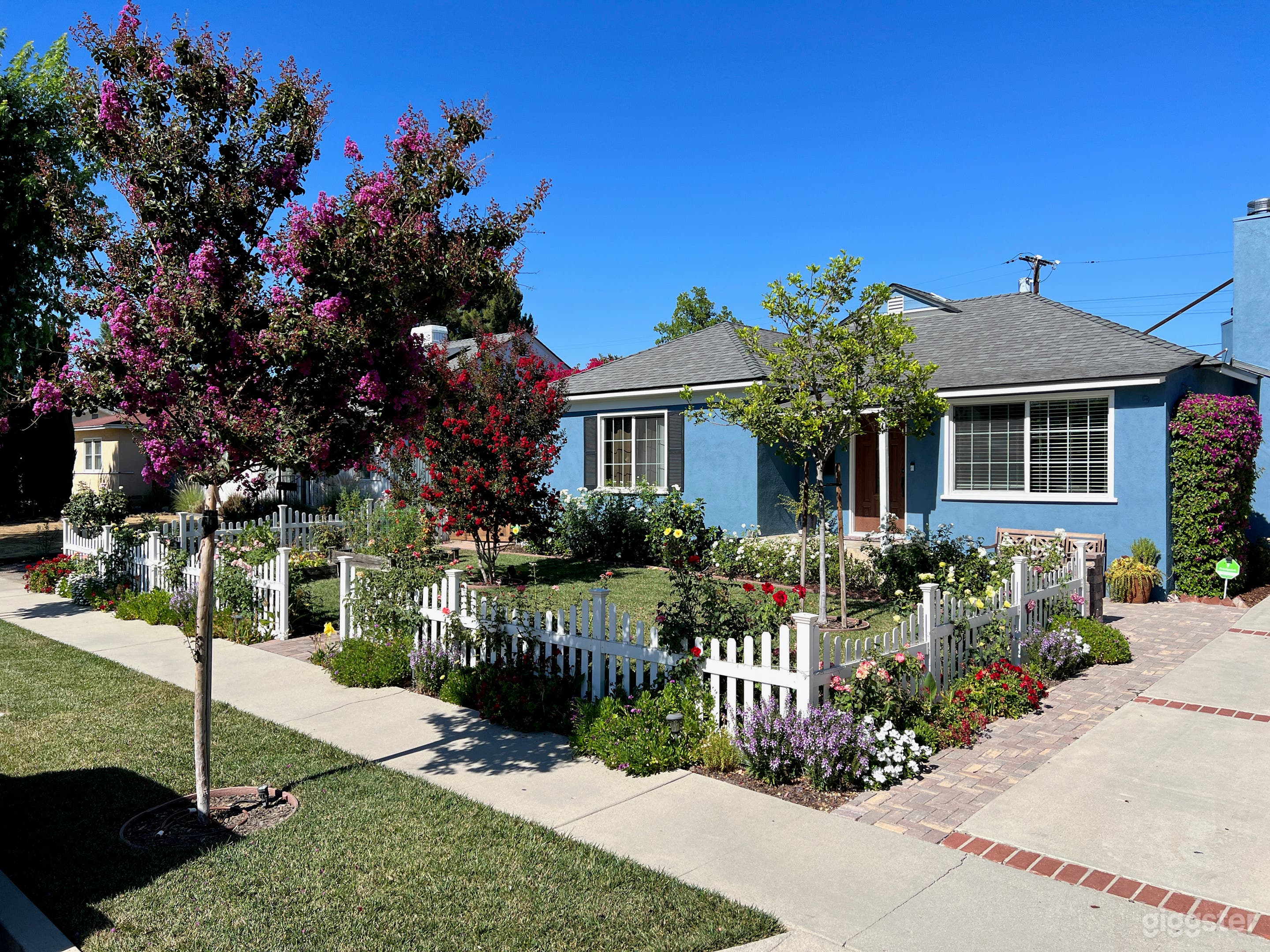 Beautiful white picket fence, colorful roses, lush green grass, freshly painted, with new roof!