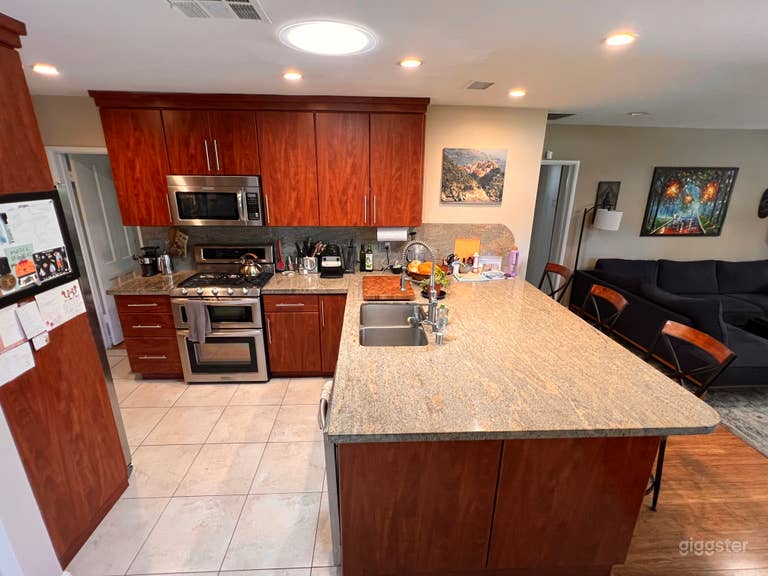  Large granite peninsula/island acts as a breakfast counter with stools on the right. 