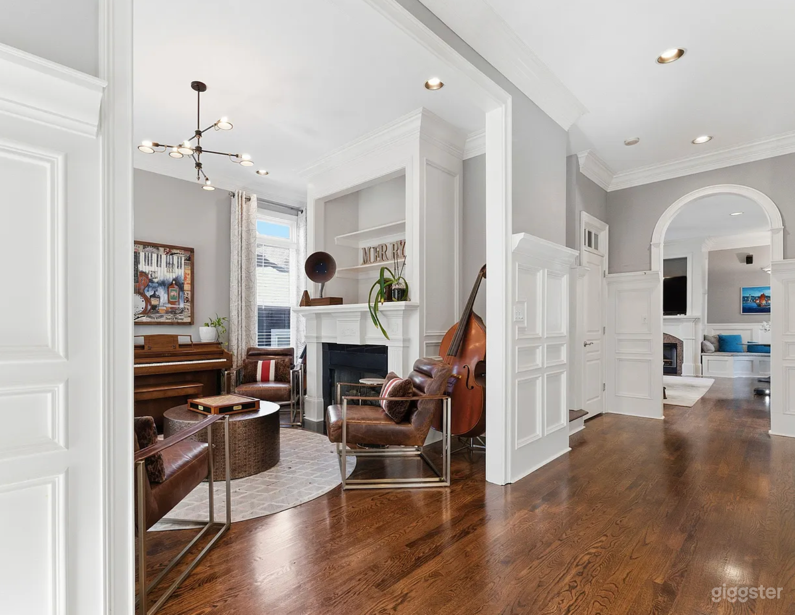 Entry to hall with crown moulding and wainscoting with music and board game room to the left.
