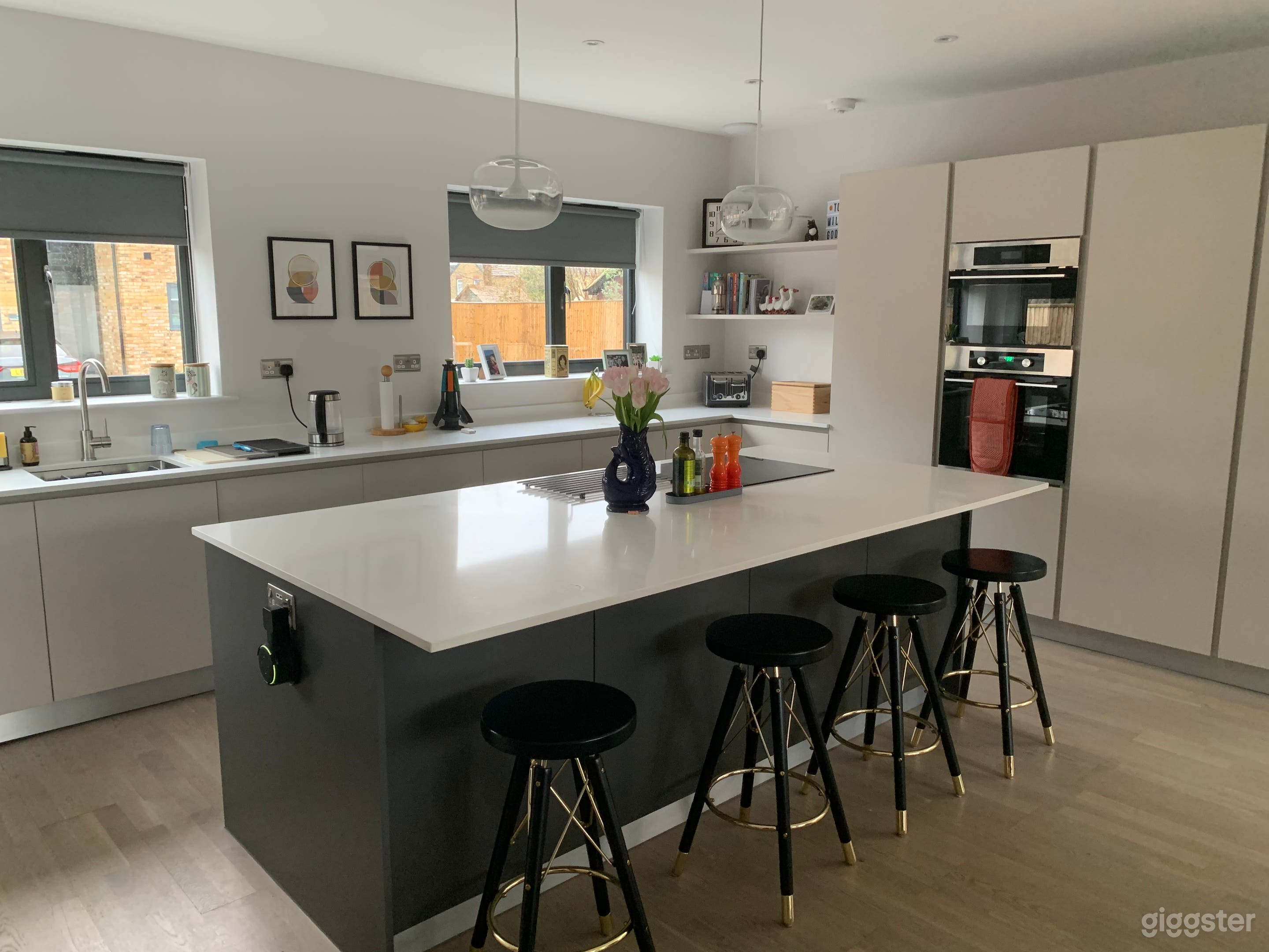 Modern open-plan kitchen brimming with natural light. Integrated appliances, smooth lines, induction hob. 