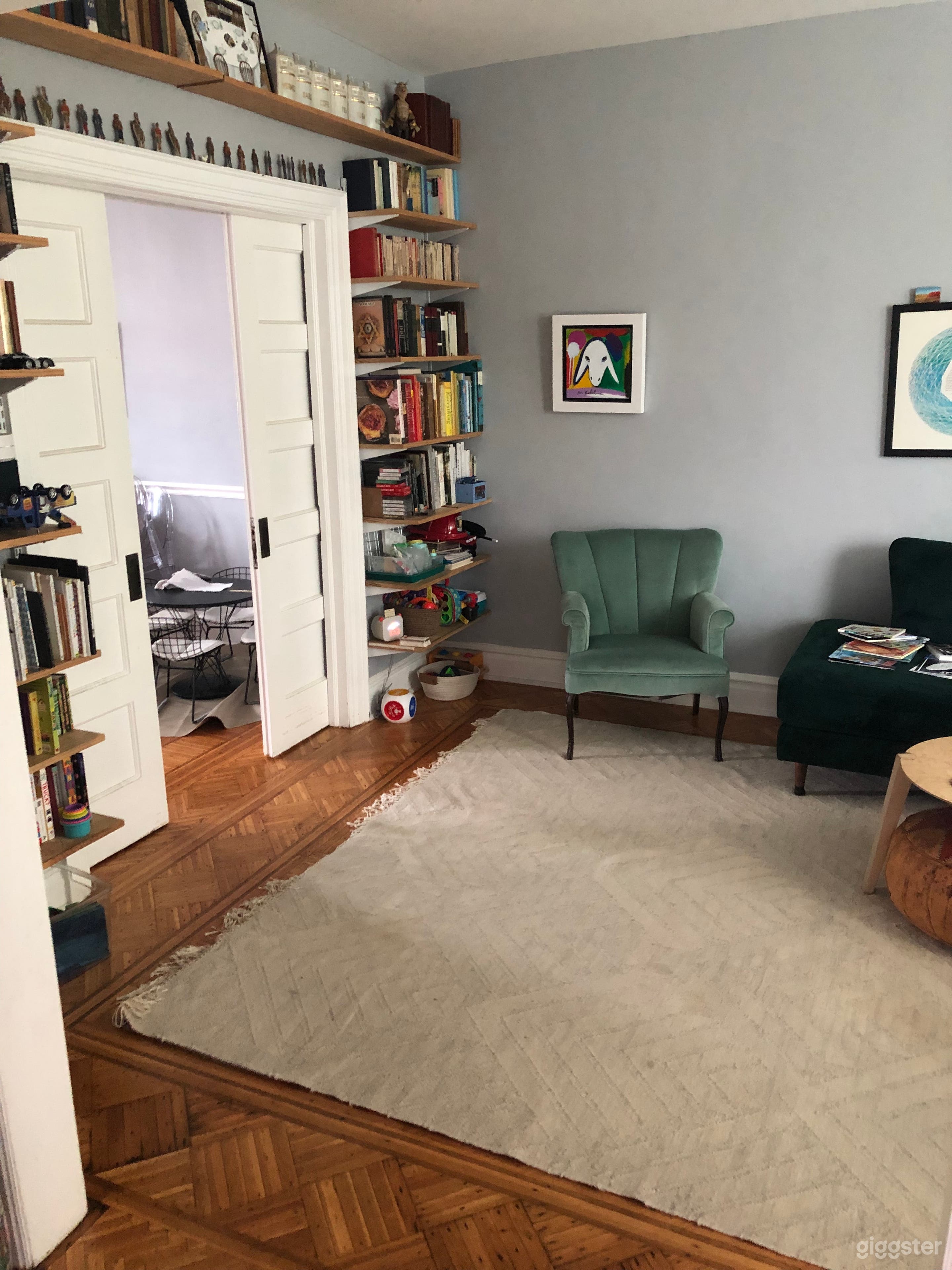 Living room with bookshelves, pocket doors, and parquet floor