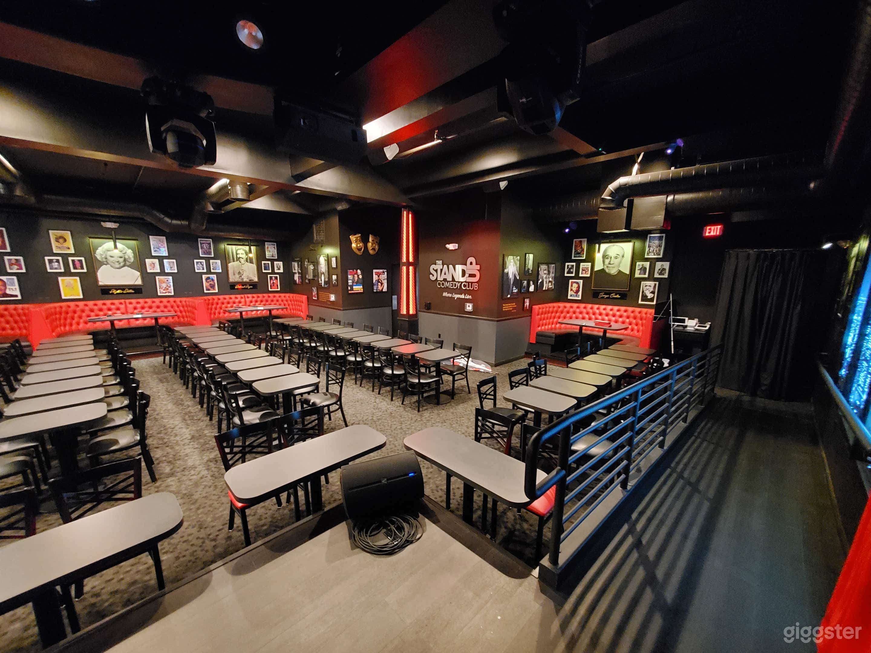 Stage view with ADA ramp, stage has retro ceiling panels and has outlets on stage for power.